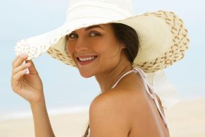 Female model wearing a sun hat by the beach