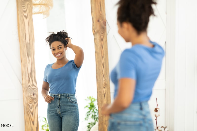cheerful lady posing in mirror after slimming figure