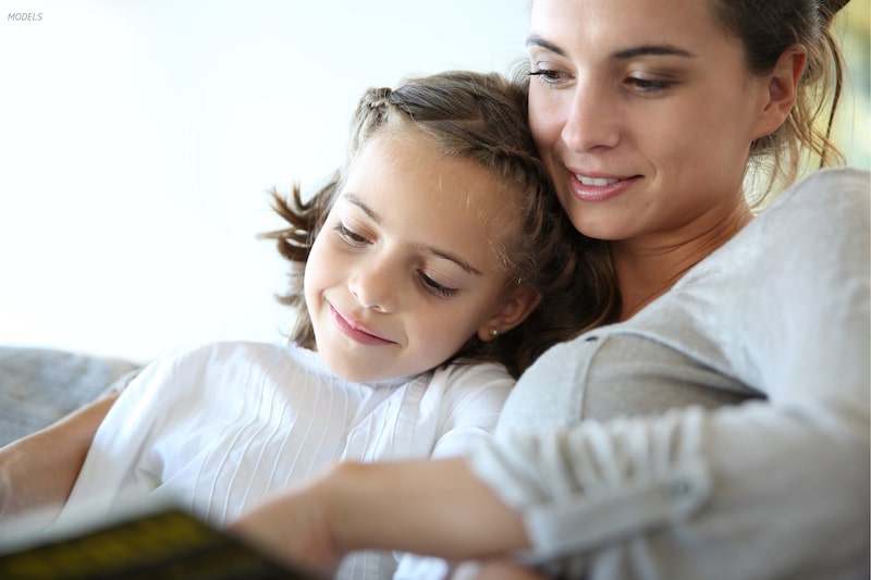 Daughter sitting on mother's lap